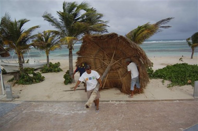 Workers remove a palm shade from the beach in preparation for the arrival of Tropical Storm Alex as winds begin to increase in Mahaual, Mexico, on Saturday.